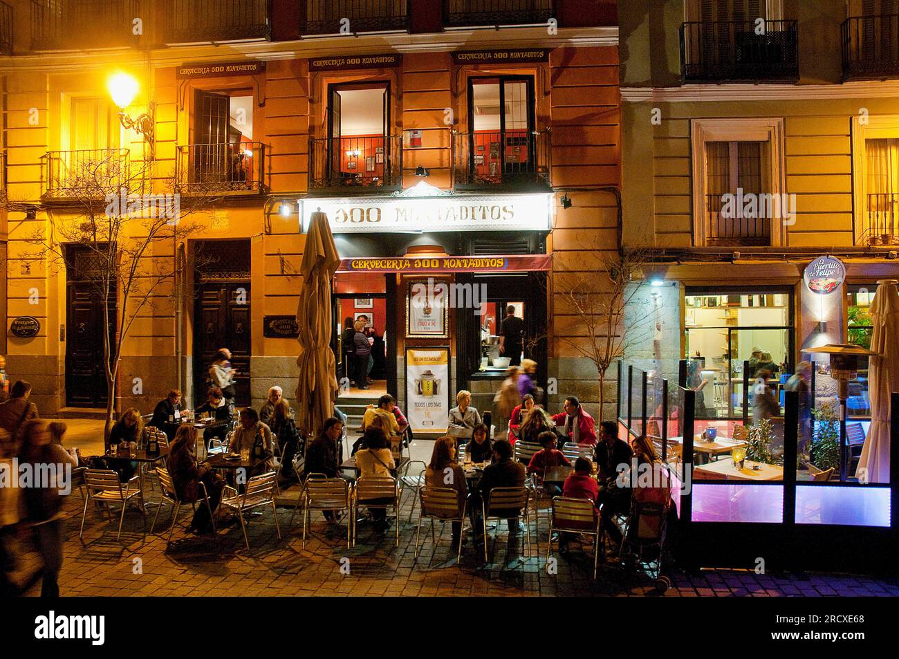 People sitting on terrace at night. Felipe V street, Madrid, Spain. Stock Photo