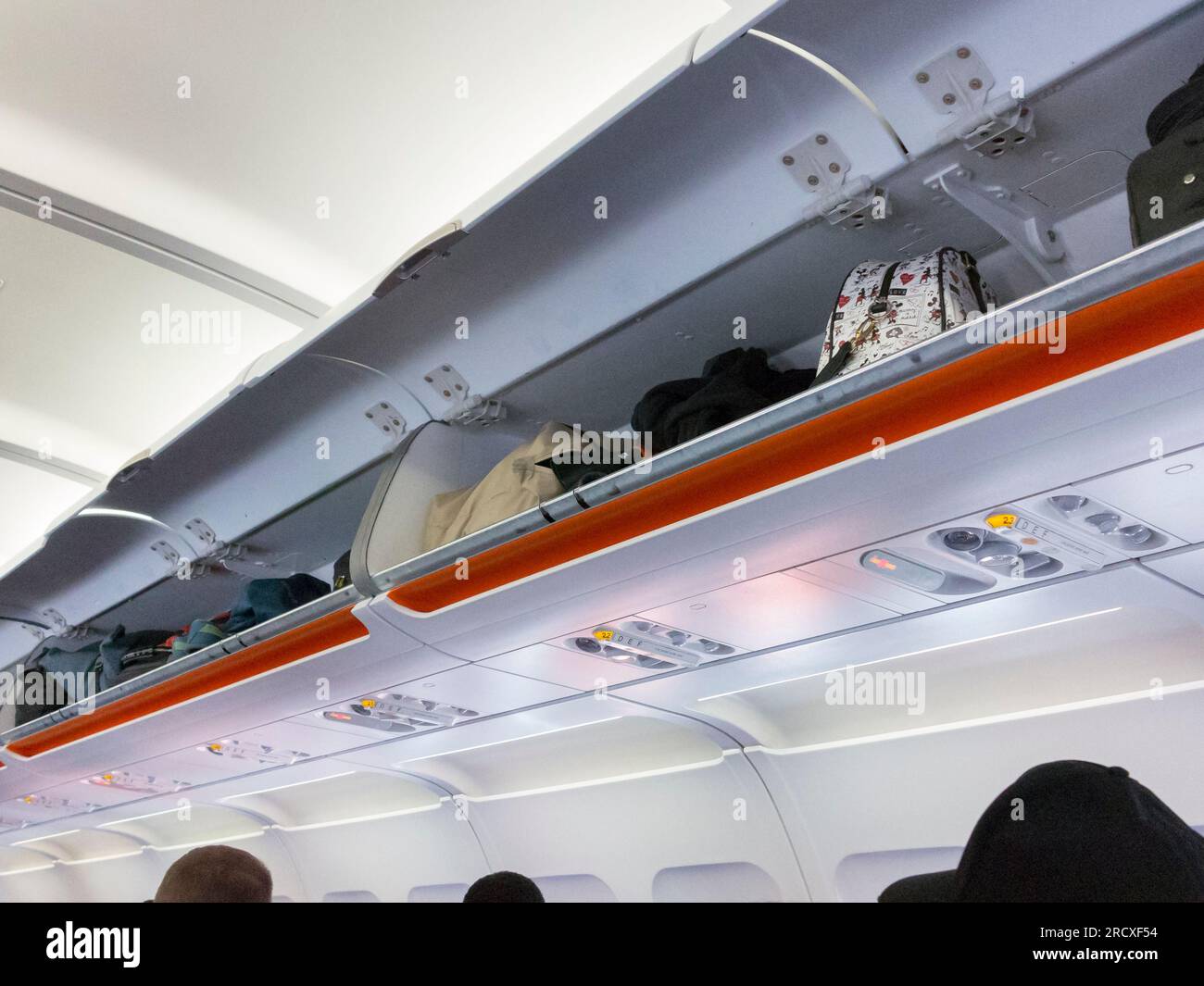 Luggage in overhead compartment in airplane cabin Stock Photo Alamy