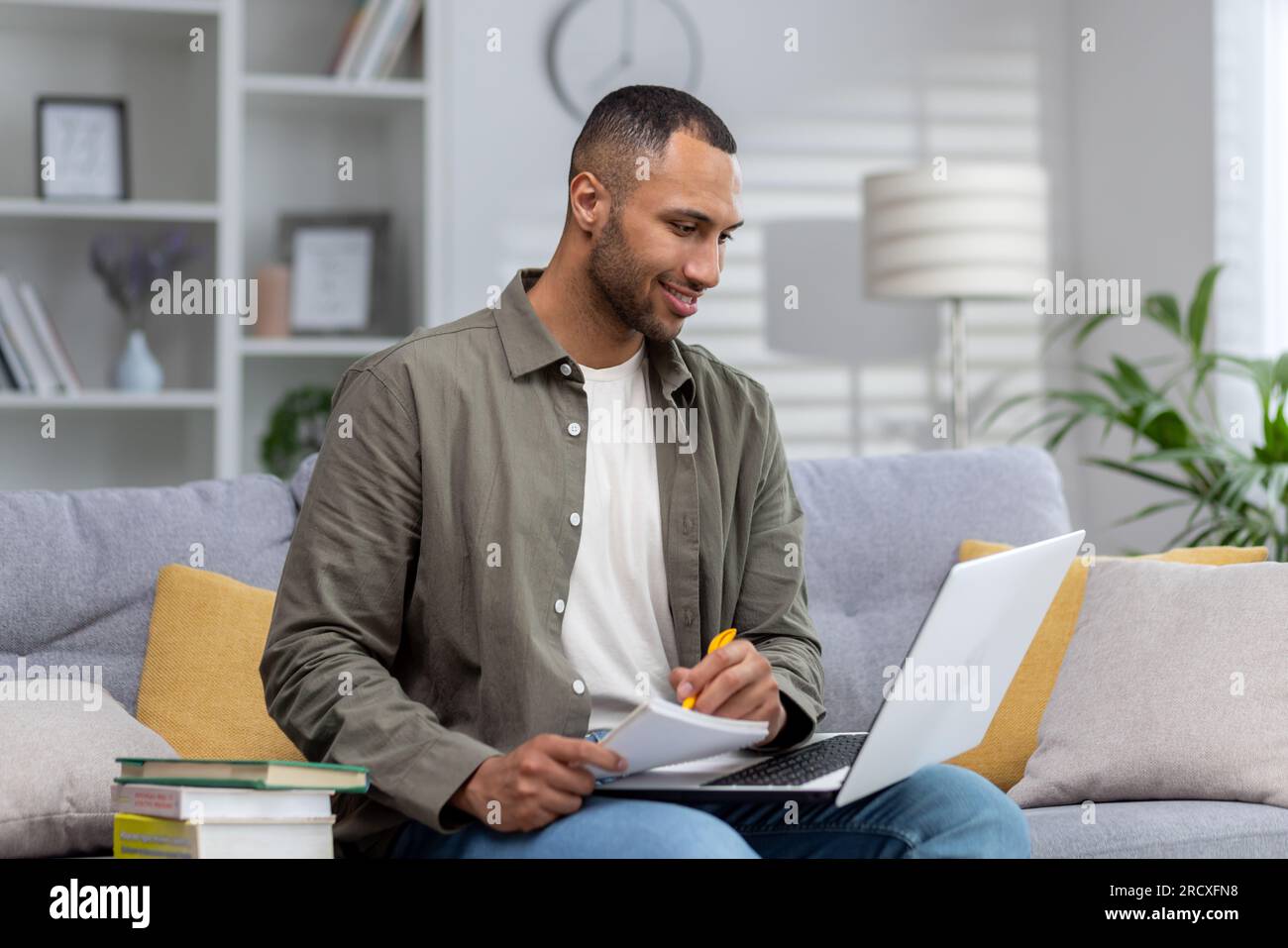 Portrait of a smiling young African American man studying at home ...