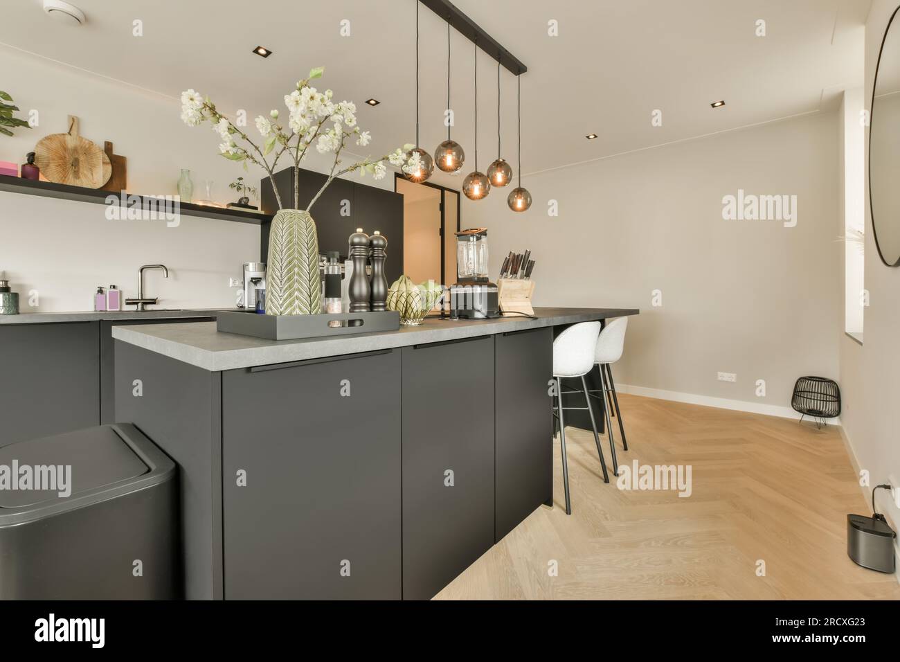 A beautiful kitchen with dark wood cabinets, marble countertops, chairs  sitting at the island, and stainless steel appliances. No brands or names  Stock Photo - Alamy