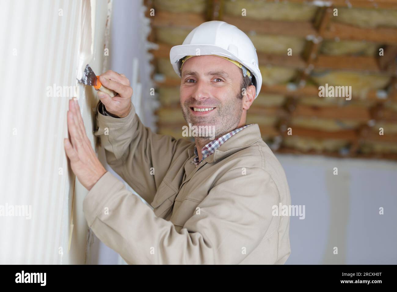 builder in hardhats with plastering tools indoors Stock Photo