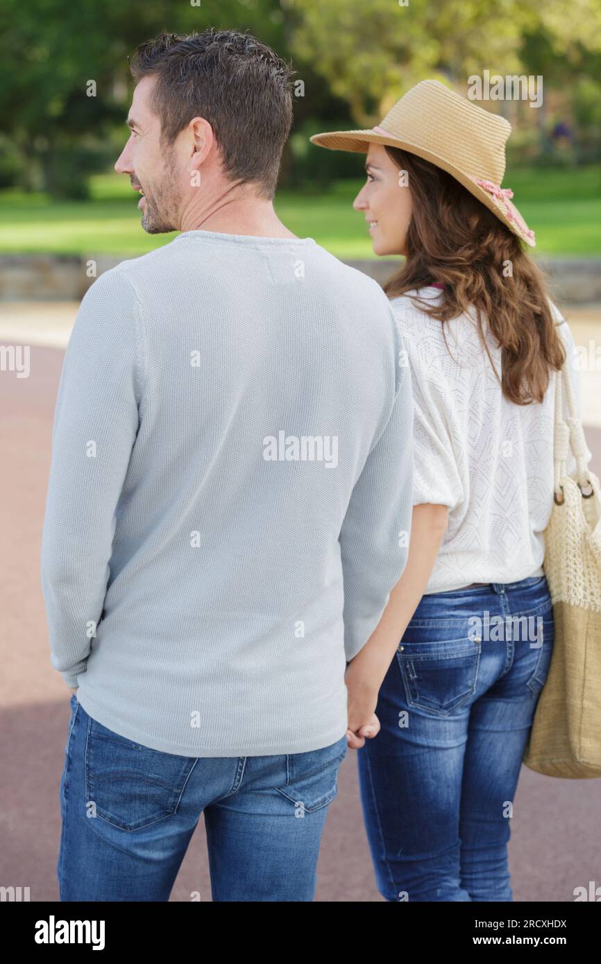 rear view of couple walking in park holding hands Stock Photo