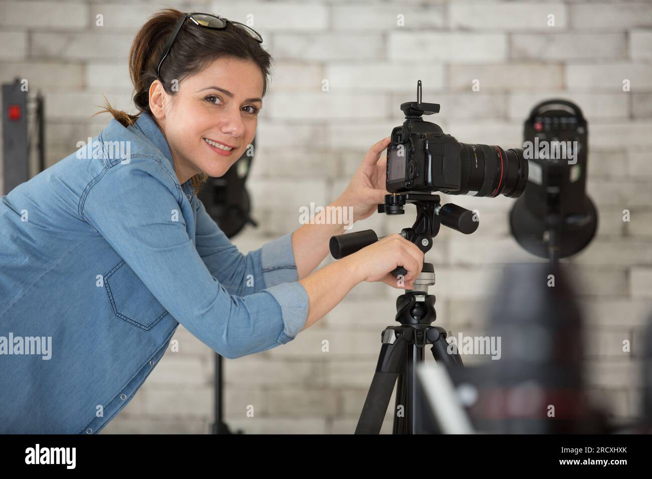 female photographer setting up camera on tripod Stock Photo Alamy