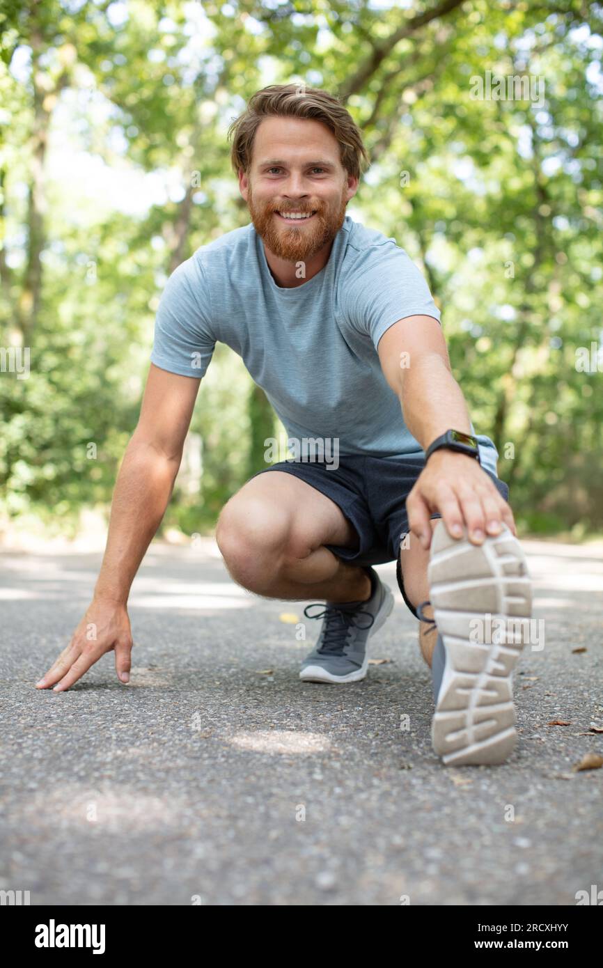 Man jogger stretching legs doing hi-res stock photography and images ...