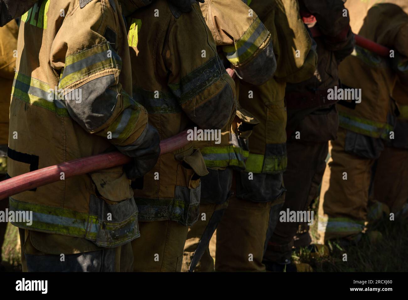 Firefighters and rescue training. Firefighter spraying high pressure water to fire Burning fire flame background Stock Photo