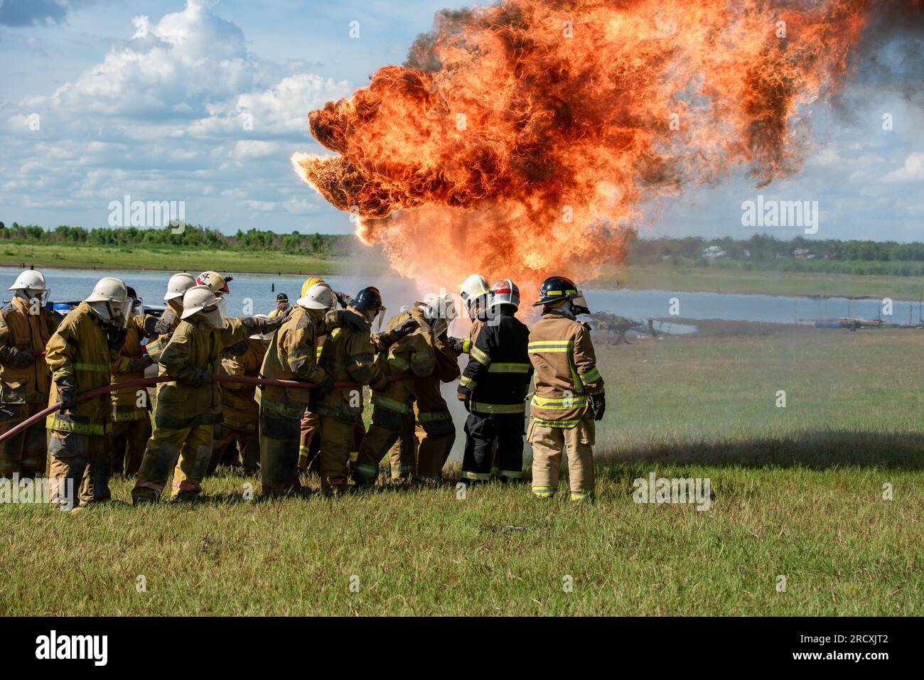 Firefighters and rescue training. Firefighter spraying high pressure water to fire Burning fire flame background Stock Photo