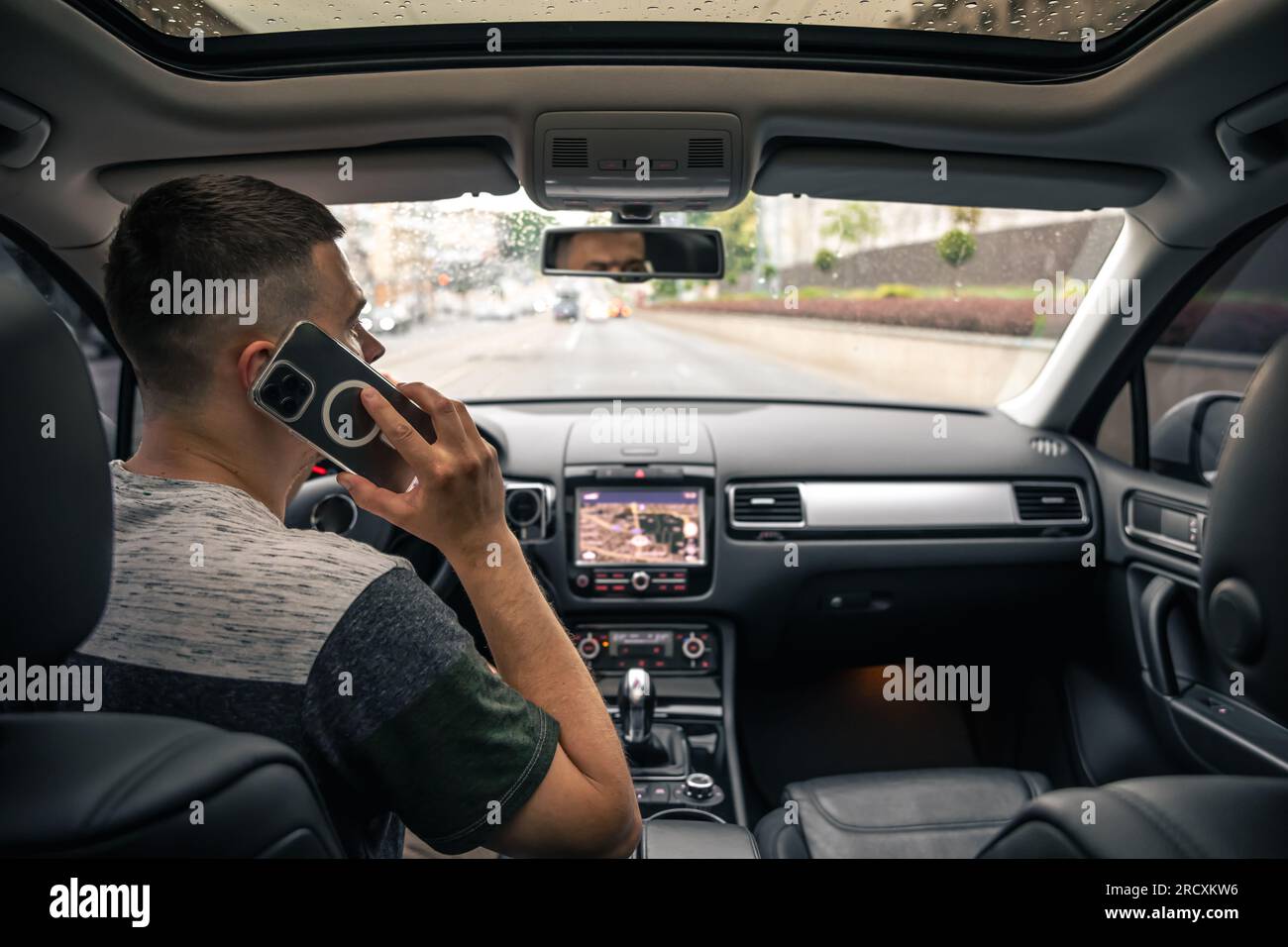 Businessman talking on cell phone while driving. Stock Photo