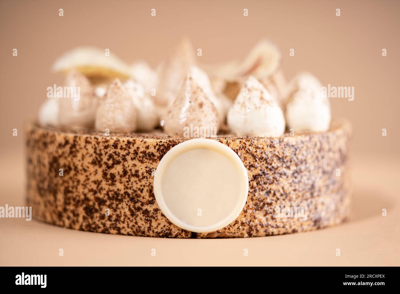 A delicious-looking dessert of a round cake on a brown plate, topped with a generous helping of fluffy white whipped cream Stock Photo