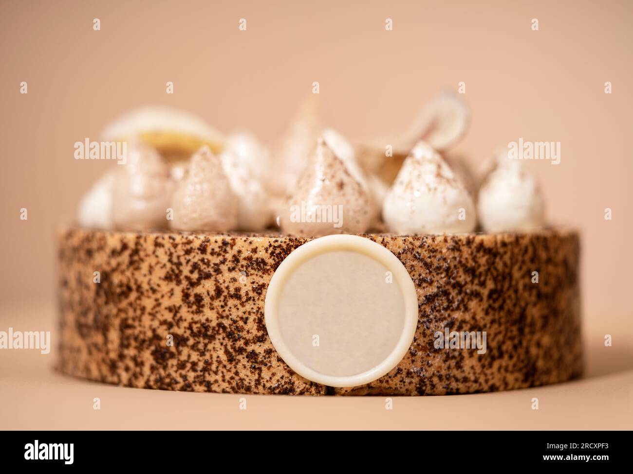 A delicious-looking dessert of a round cake on a brown plate, topped with a generous helping of fluffy white whipped cream Stock Photo
