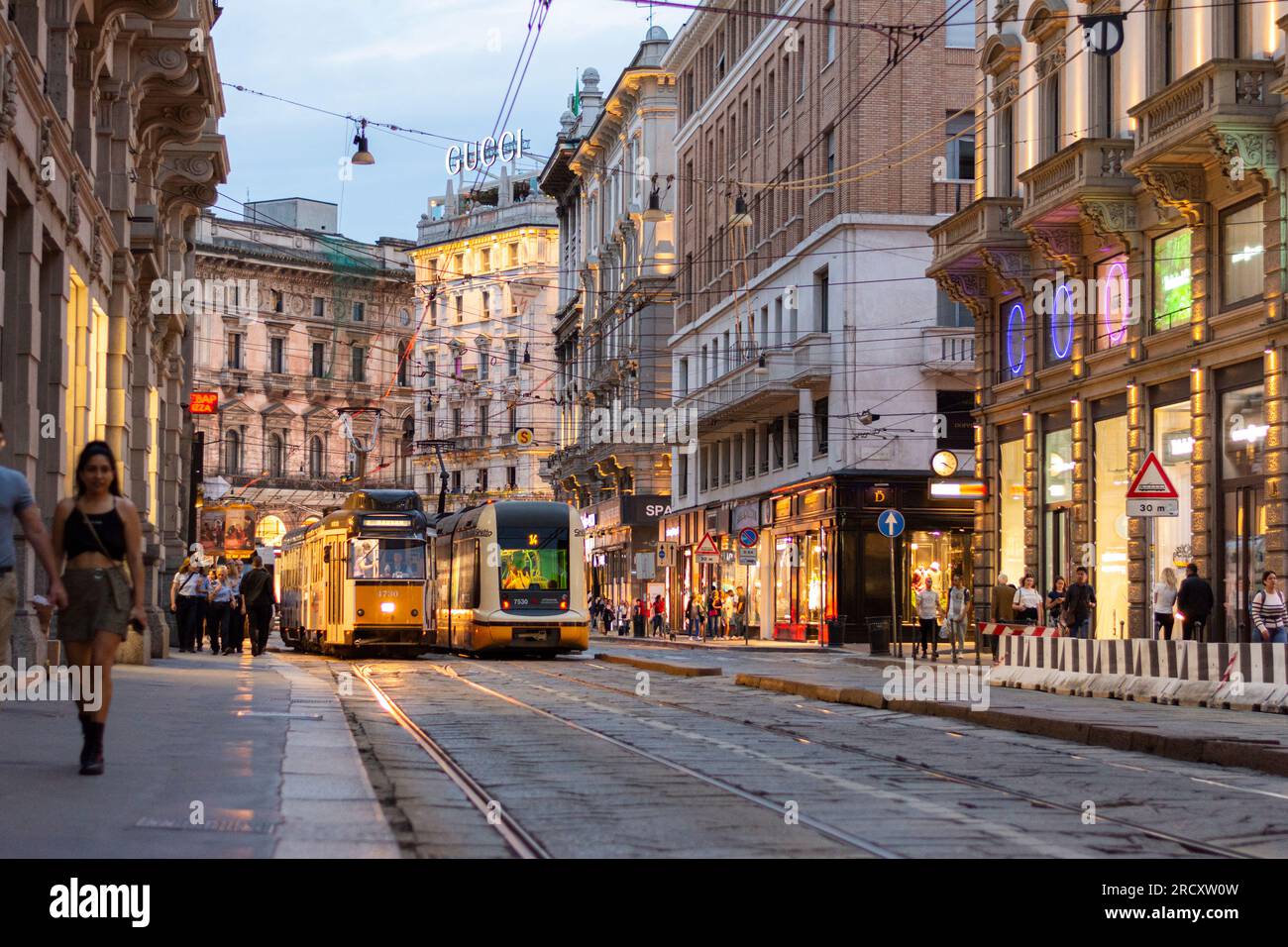 A vintage tram and a newer model cross paths - Milan, Italy Stock Photo