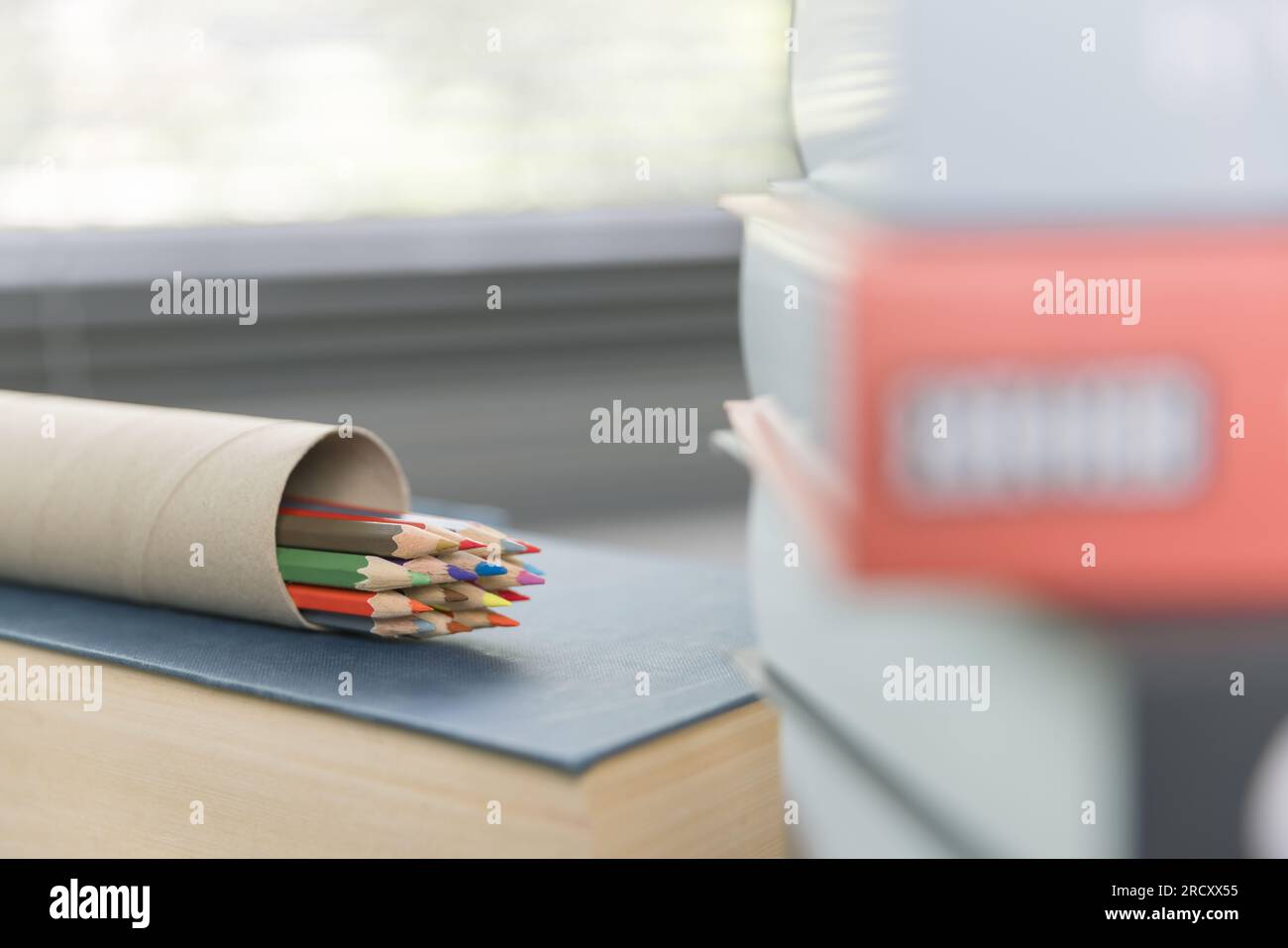 School supplies on wooden table in warm interior, school books on table, education concept. Stock Photo