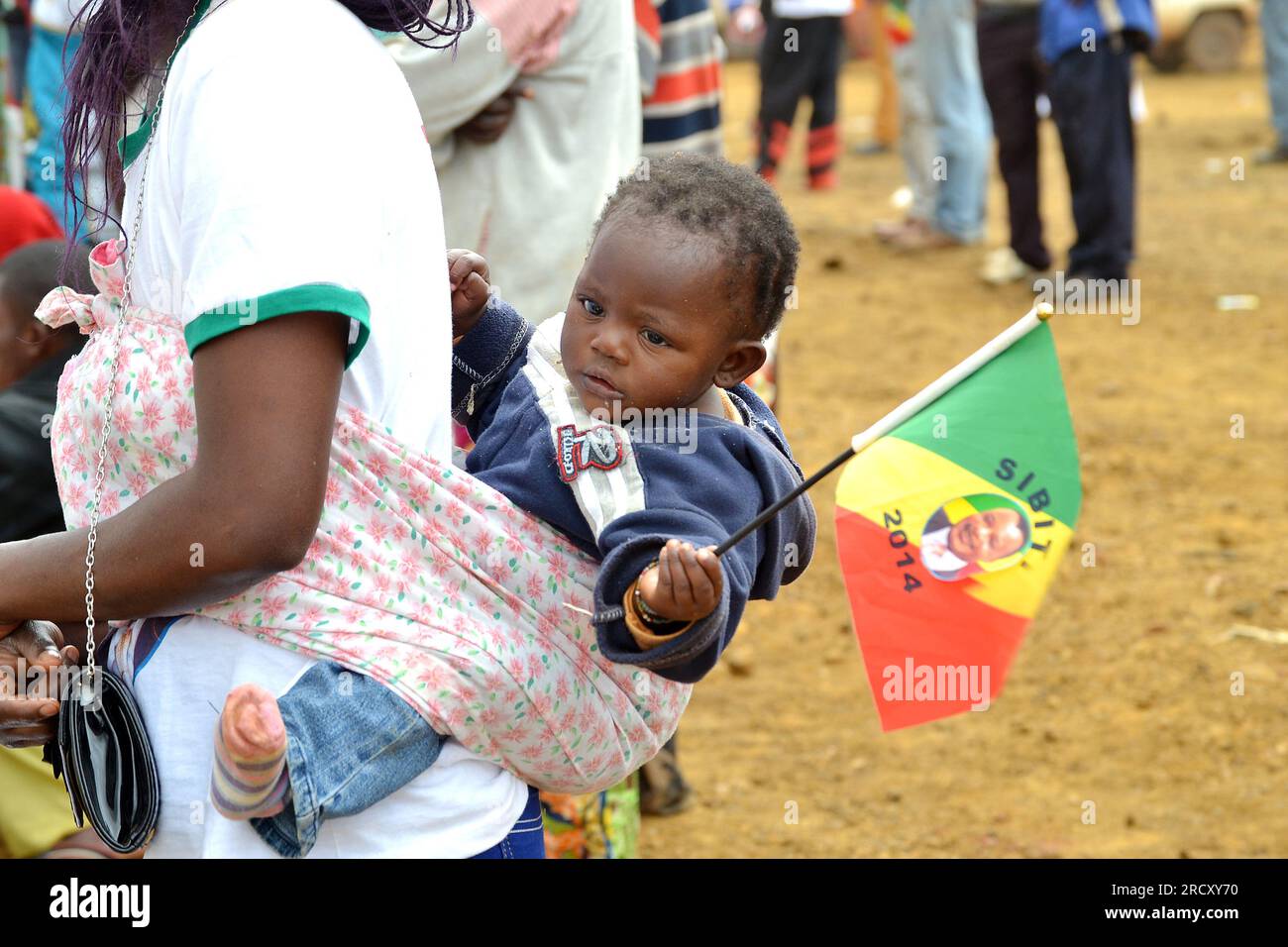 A baby carried on his back by his mother in Sibiti (located between Brazzaville and Pointe-Noire), during an official ceremony, 13 August 2014 Stock Photo