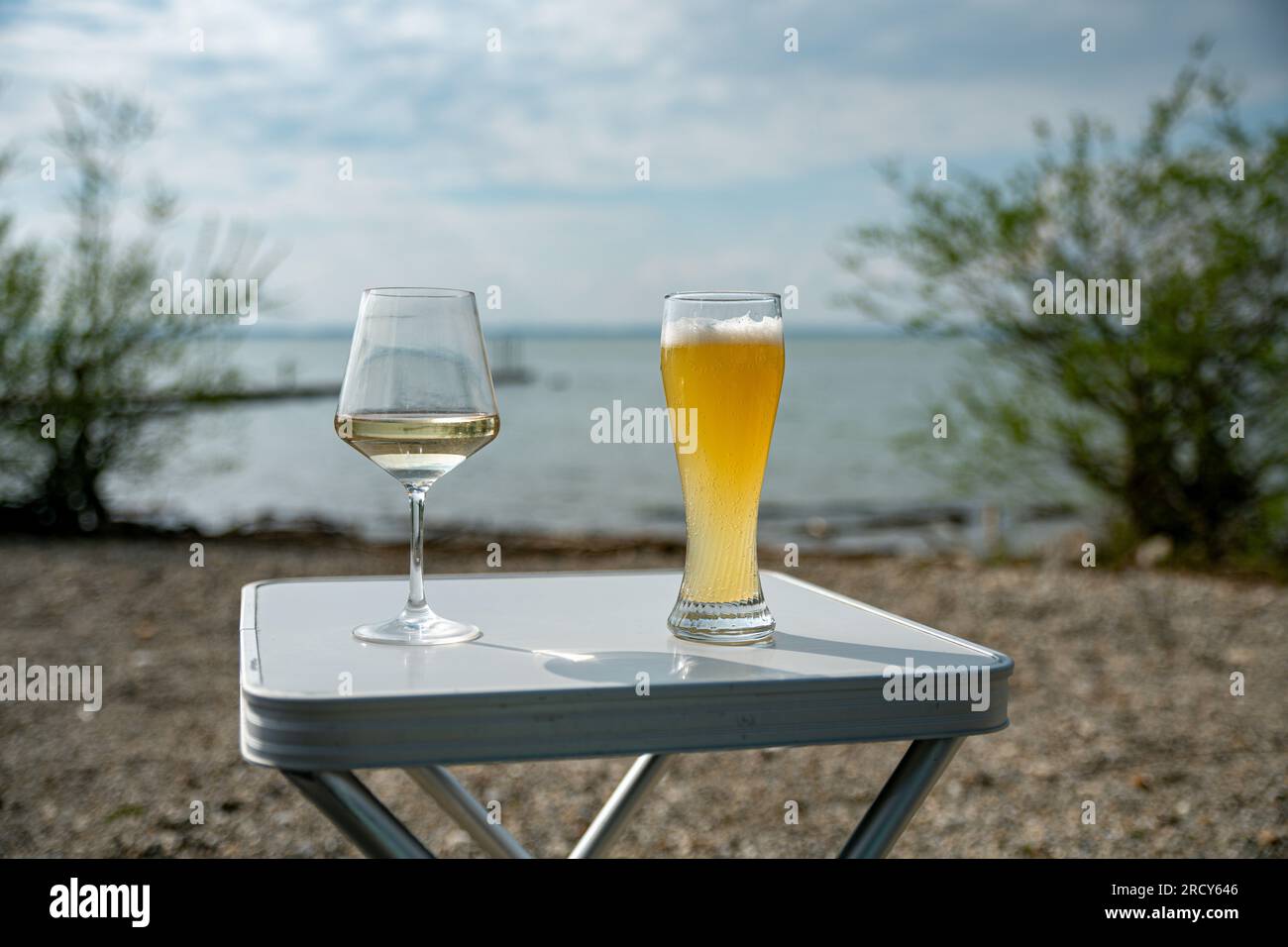 camping table with drinks such as a glass of wine and a glass of beer Stock Photo