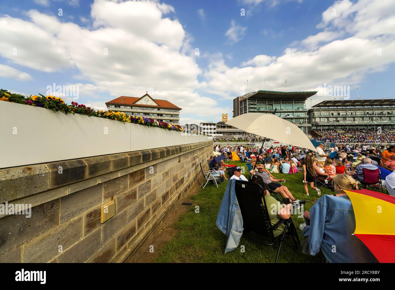 Horse race in York, England. People sitting in the lawn seats to see the horse races, picnic, drink, eat, bet and enjoy time with friends and family. Stock Photo