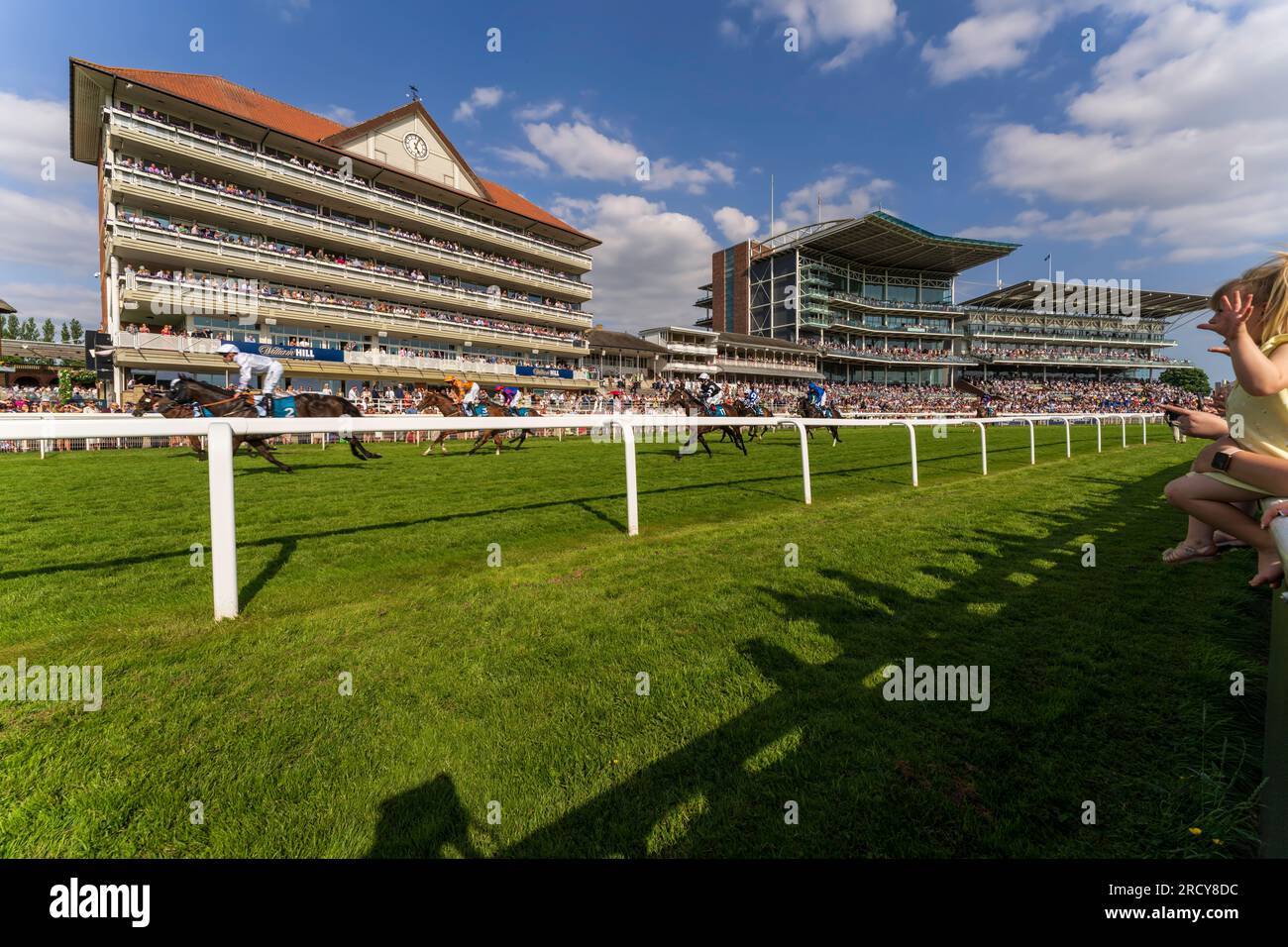 York horse race, fans cheer as race horses approach the finish line. Horse racing days are major events in England, UK, part of the British culture. Stock Photo