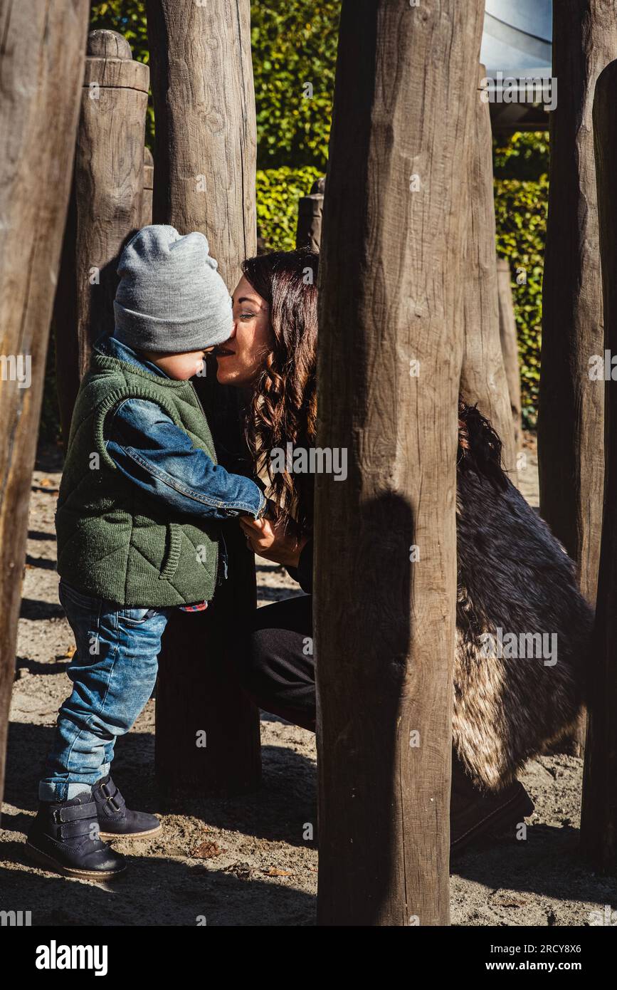 Contented emotion and deep parental love concept with a mother consoling her shy little boy after a fall in playground. Emotional content illustration Stock Photo