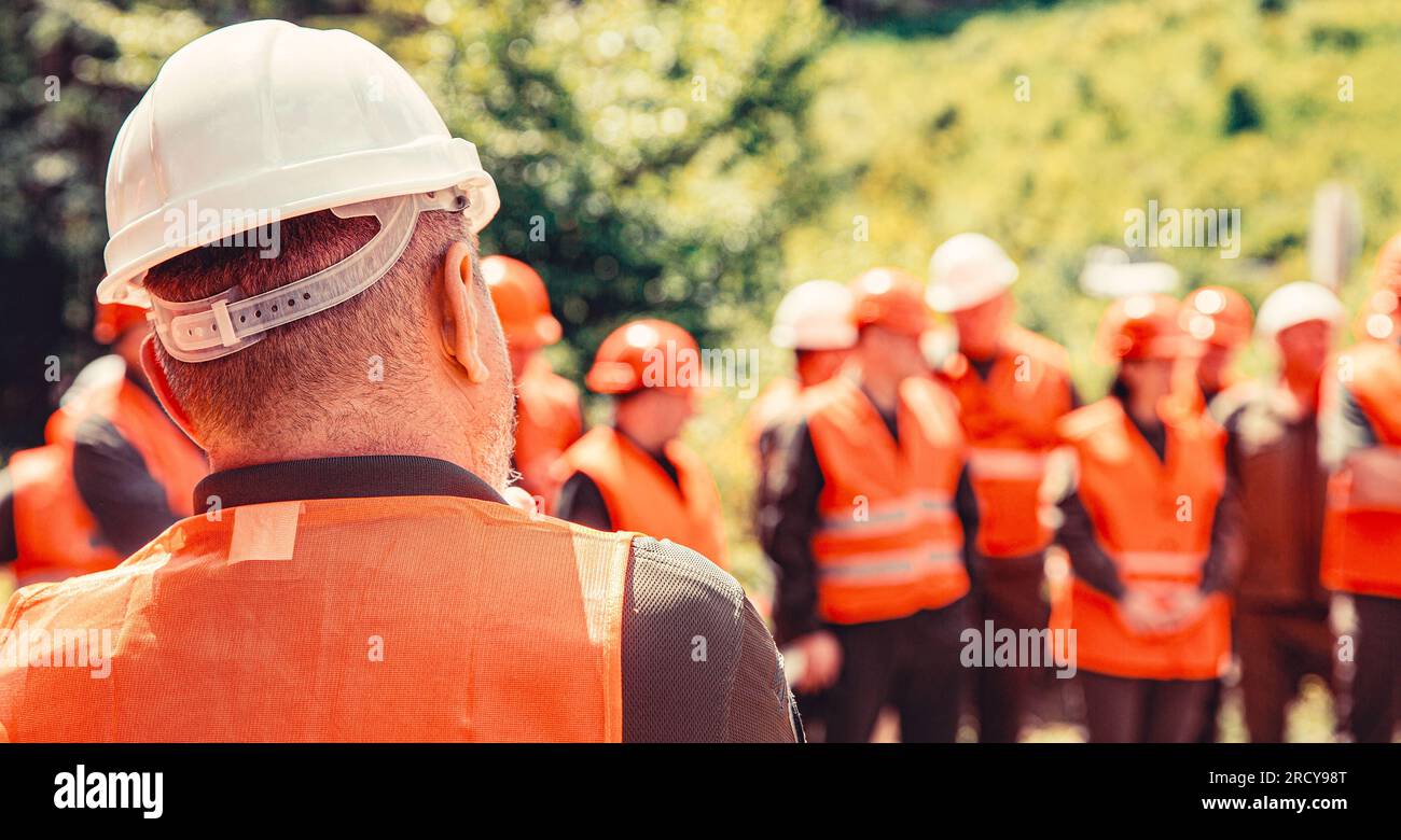 Helmet builder. Worker group wearing vest, safety. Building concept. Architector, engineers on constructing site. Builder man Stock Photo