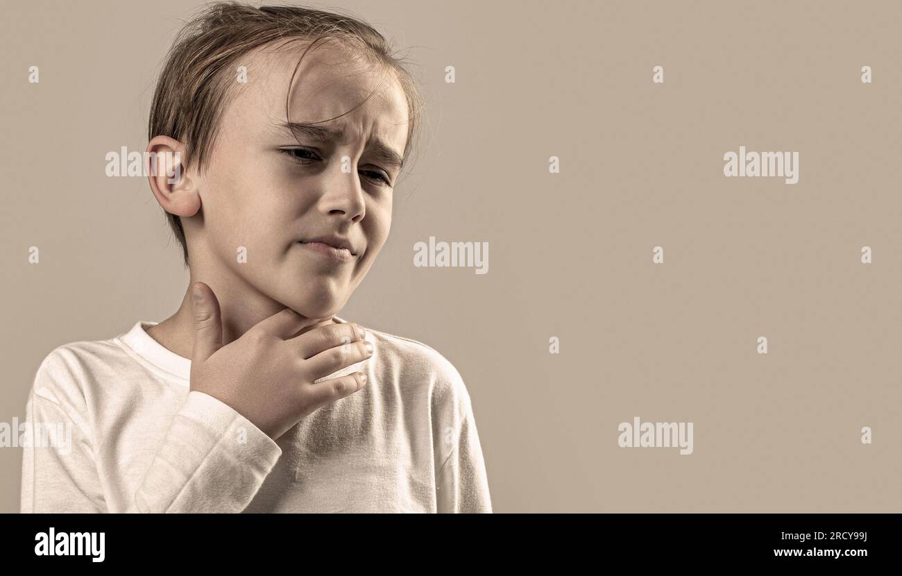 Child has a sore throats. Young boy feels that his throat is pain. Ill little boy with sore