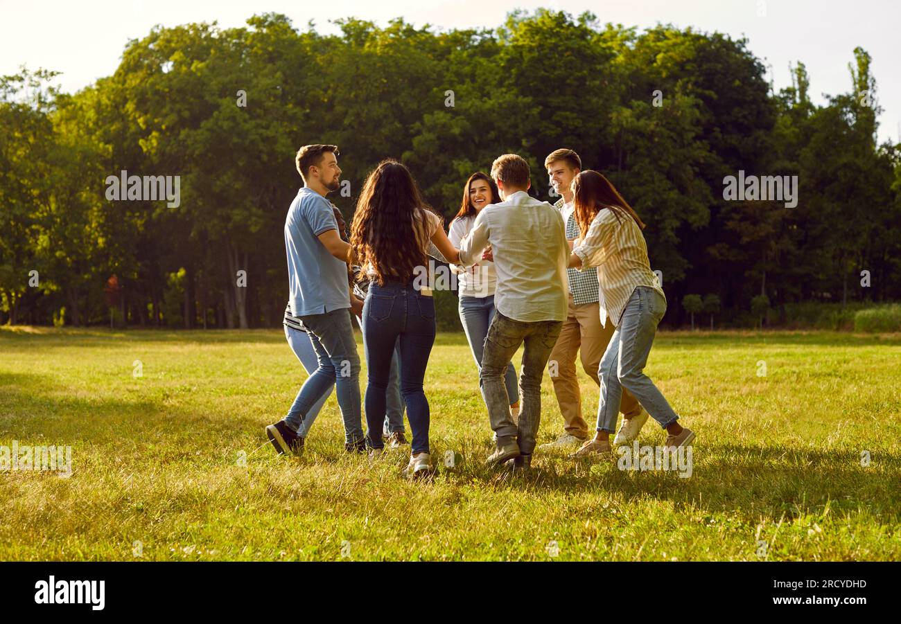 Group of happy friends are having fun and dancing in a circle in the ...