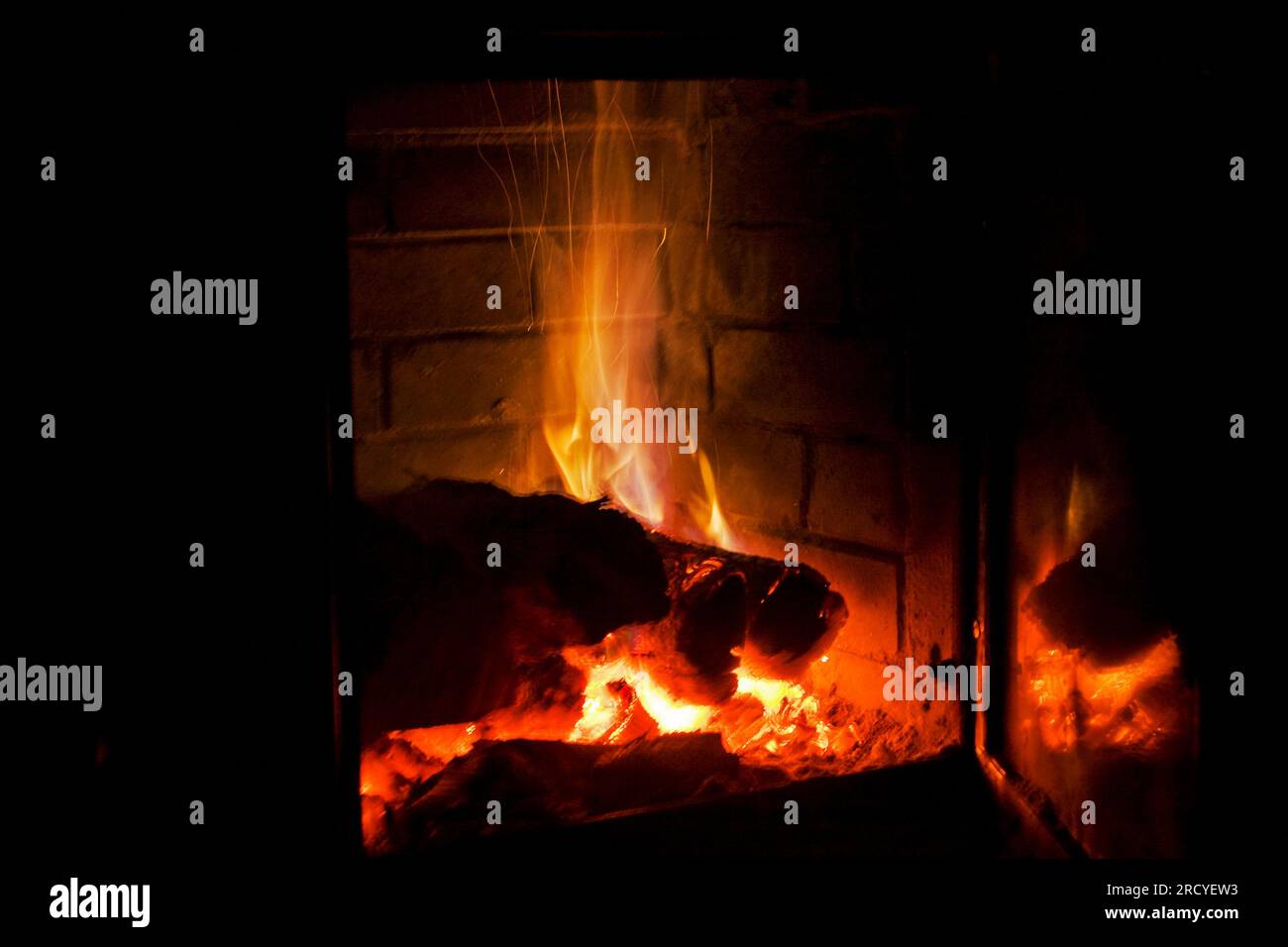 fire burns with wood in a fireplace with blue gas on a black background