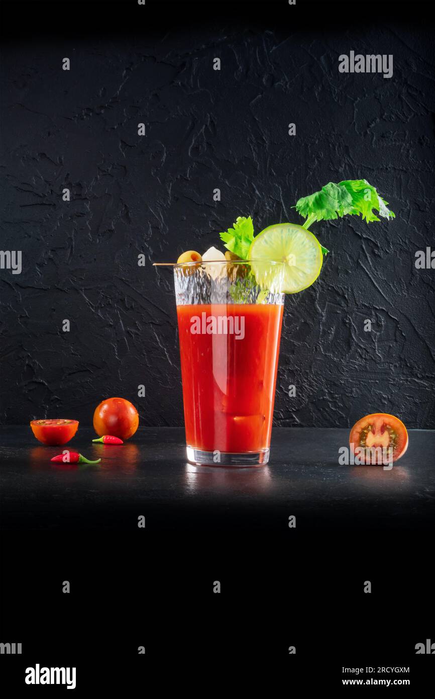 Bloody Mary Cocktail in glasses with garnishes. Tomato Bloody Mary spicy  drink on black stone background with copy space Stock Photo - Alamy