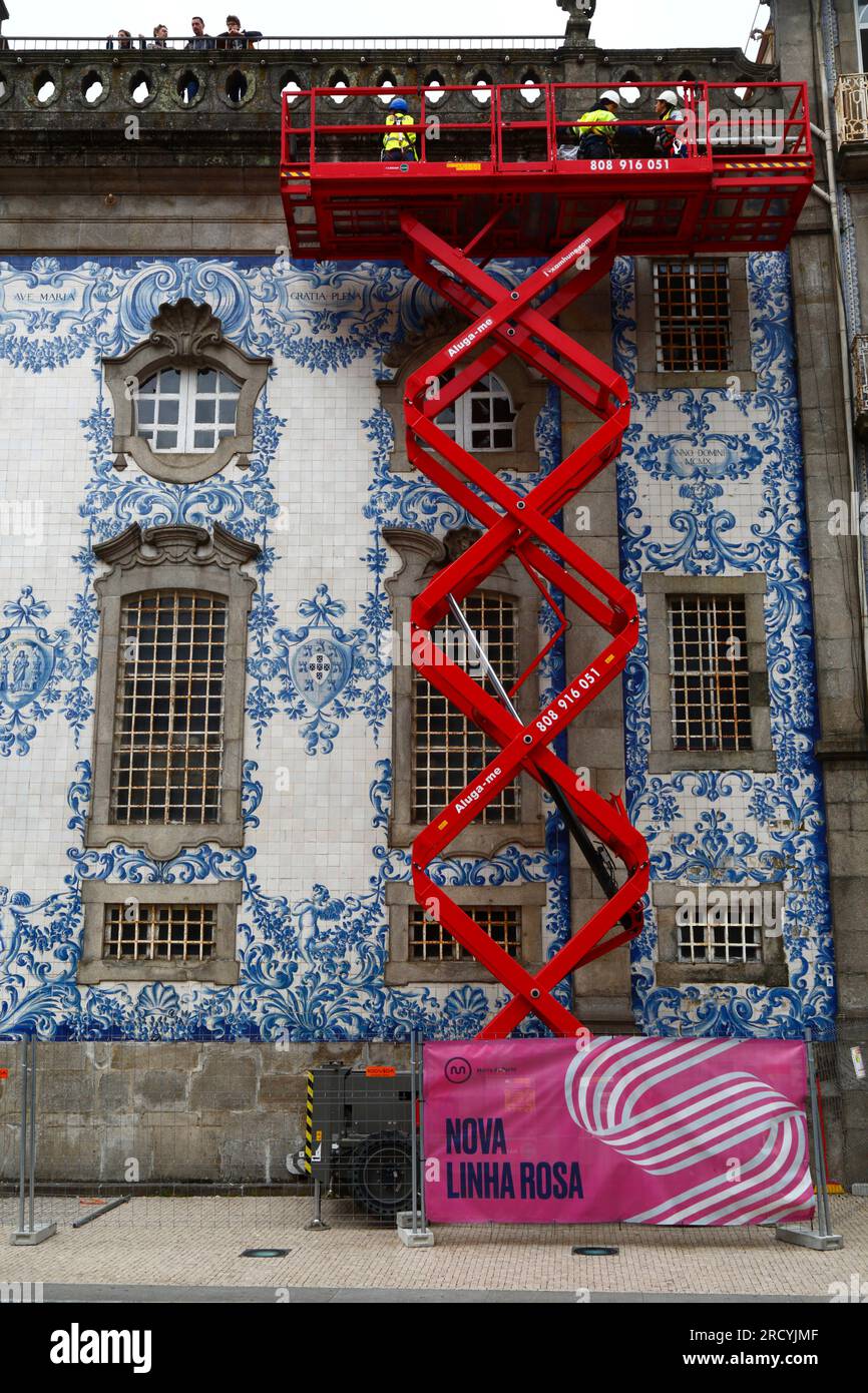 Workers on scissor lift elevated platform doing maintenance inspection on side of Igreja do Carmo church, Porto / Oporto, Portugal Stock Photo