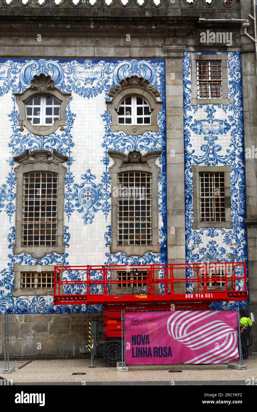 Scissor lift elevated platform parked next to azulejo tile covered side wall of Igreja do Carmo church, Porto / Oporto, Portugal Stock Photo