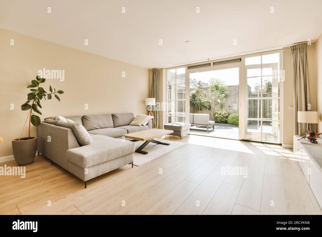 a living room with wood flooring and sliding glass doors leading to the ...