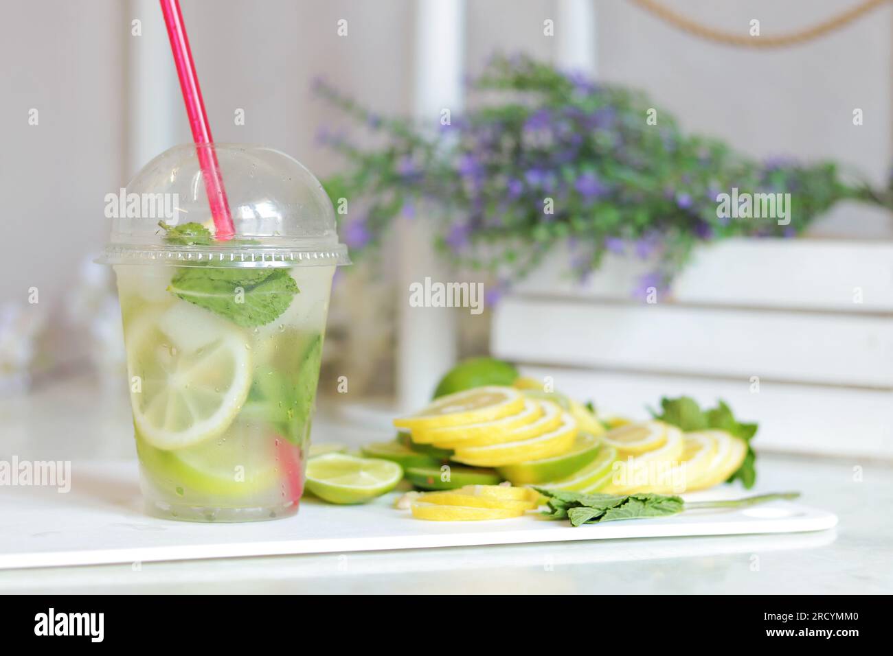https://c8.alamy.com/comp/2RCYMM0/making-homemade-mojitos-close-up-of-a-glass-with-ice-lemon-lime-and-mint-lemonade-preparation-a-plastic-cup-with-a-mojito-on-a-table-in-a-light-k-2RCYMM0.jpg