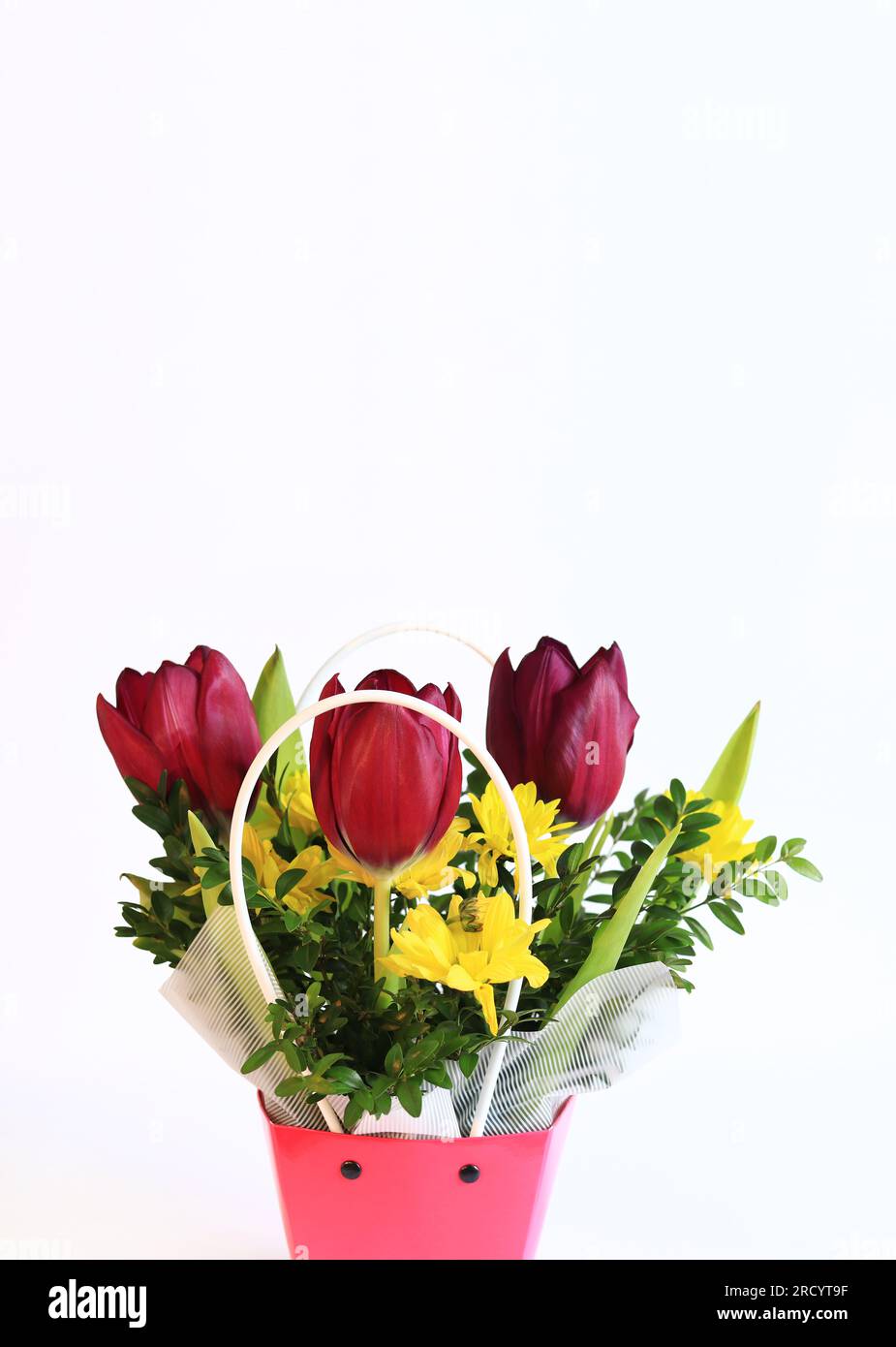 Bouquet of spring flowers with tulips in a pink cardboard basket