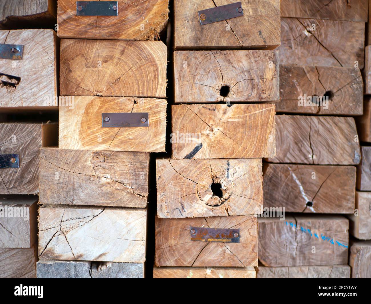 Boxshaped pile of teak wood with crack patches, made of metal plates