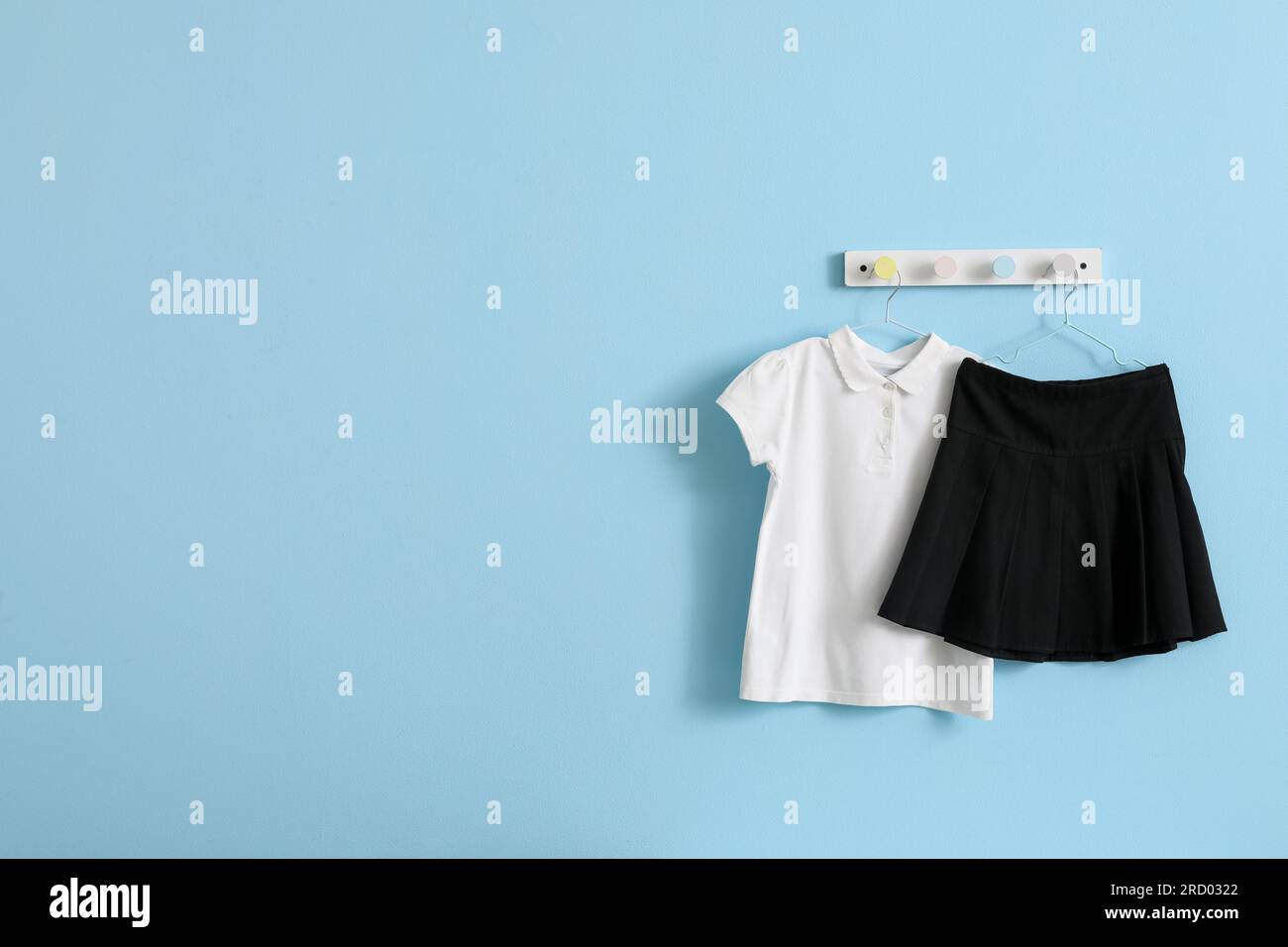 Stylish school uniform hanging on blue wall in room Stock Photo Alamy