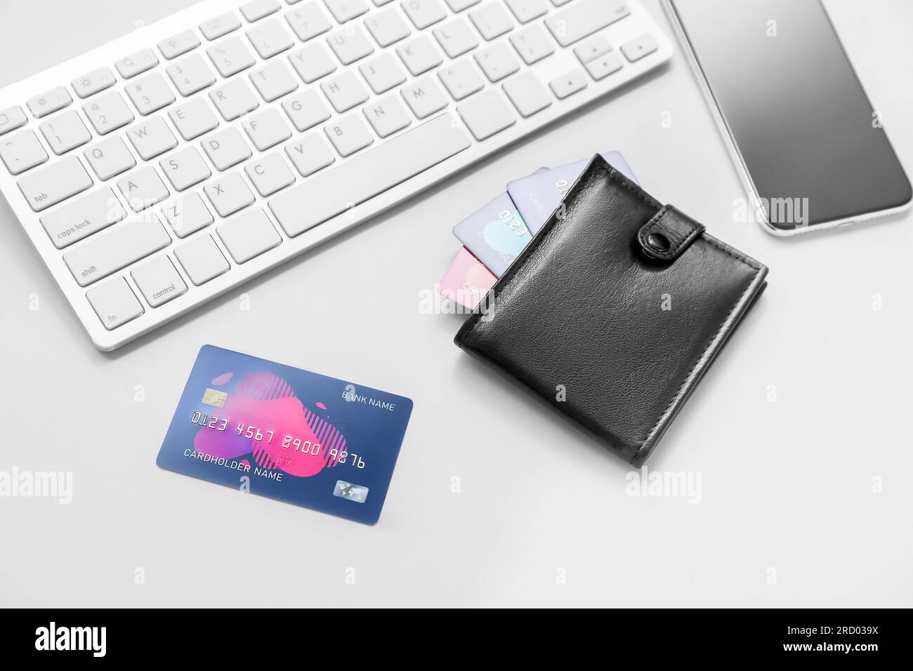 Keyboard with leather wallet, mobile phone and credit cards on grey background Stock Photo