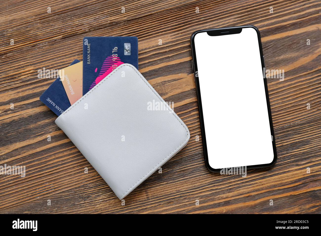 Mobile phone with wallet and credit cards on brown wooden background Stock Photo