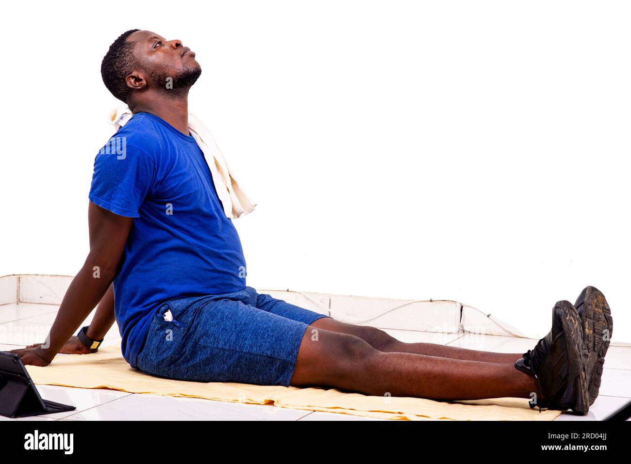 portrait of a sporty young man in sportswear sitting on the floor with ...