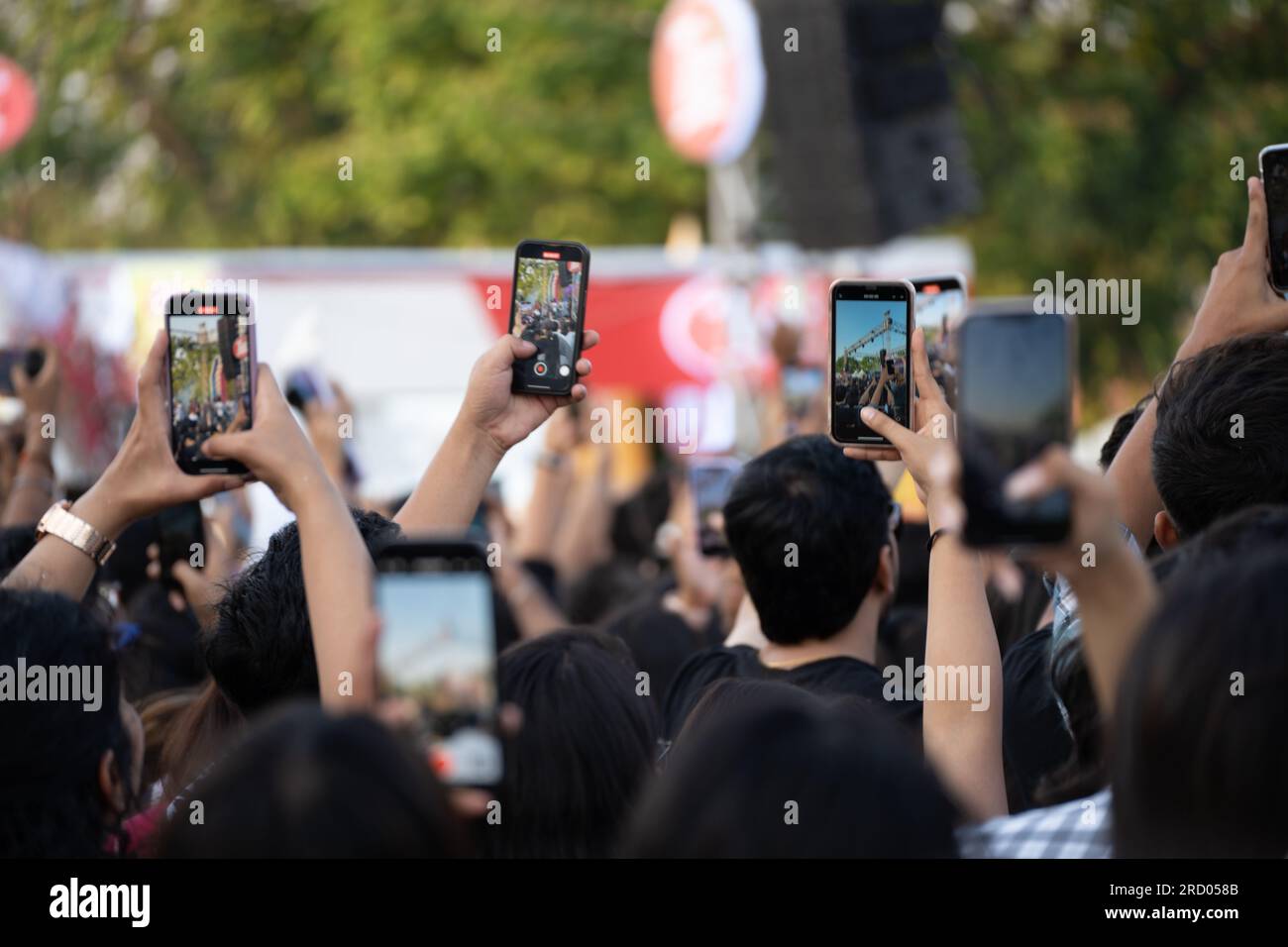 showing people throwing up hands and recording event through mobile