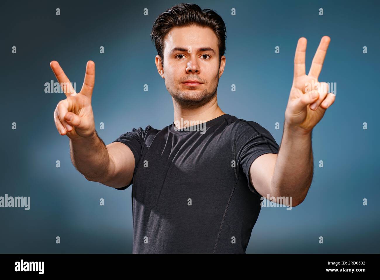 Young brunette man showing victory handsign Stock Photo