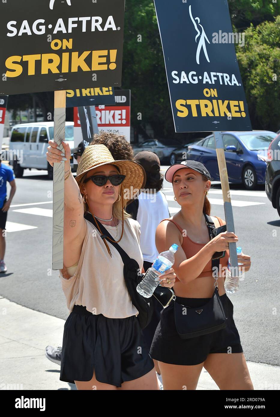 Actors Hilary Duff, left, and Francia Raisa, cast members in the television series "How I Met Your Father," carry signs on a picket line outside Paramount studios in Los Angeles on Monday, July 17, 2023. The actors strike comes more than two months after screenwriters began striking in their bid to get better pay and working conditions and have clear guidelines around the use of AI in film and television productions. (Jordan Strauss/Invision/AP) Stock Photo