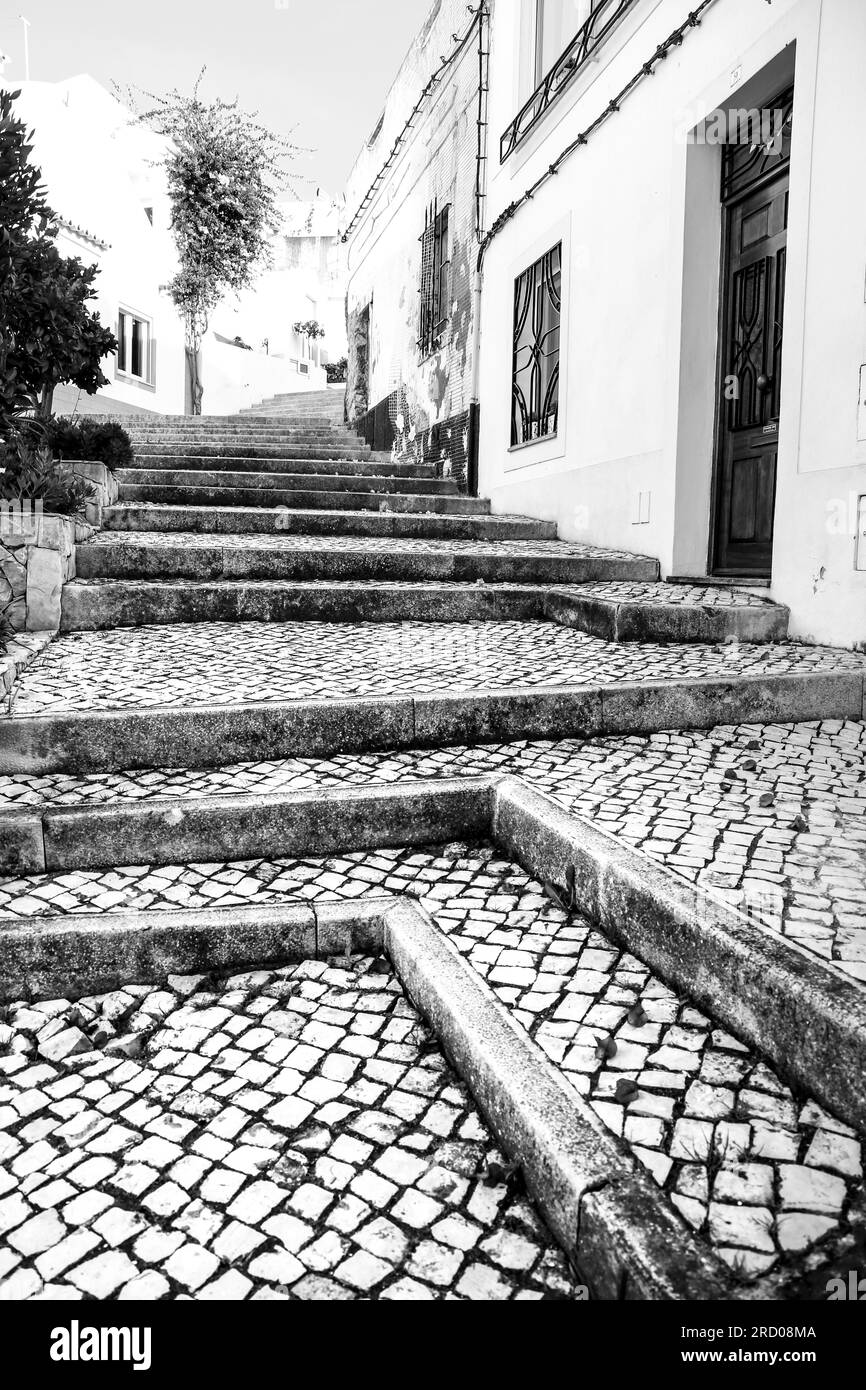 Cobblestone streets with typical Portuguese facades in Ferragudo town, Portugal Stock Photo
