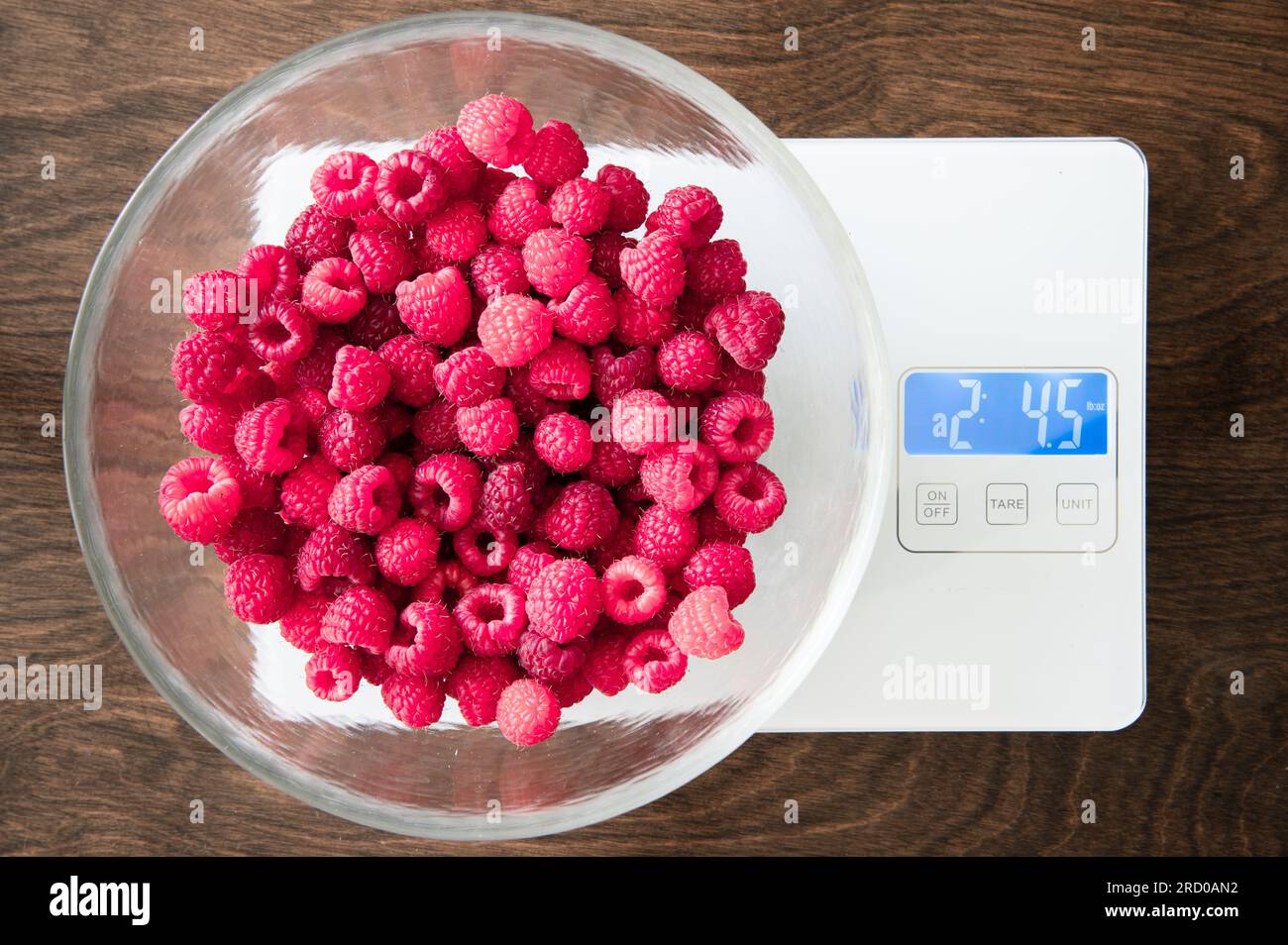 Glass bowl of red raspberries on a kitchen scale Stock Photo