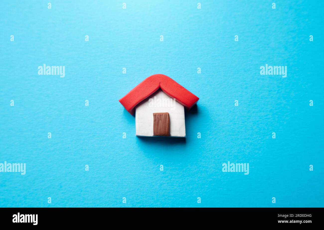 Miniature house on a blue background. Buying and selling housing. Real estate market review. Construction industry. Design and architectural services. Stock Photo