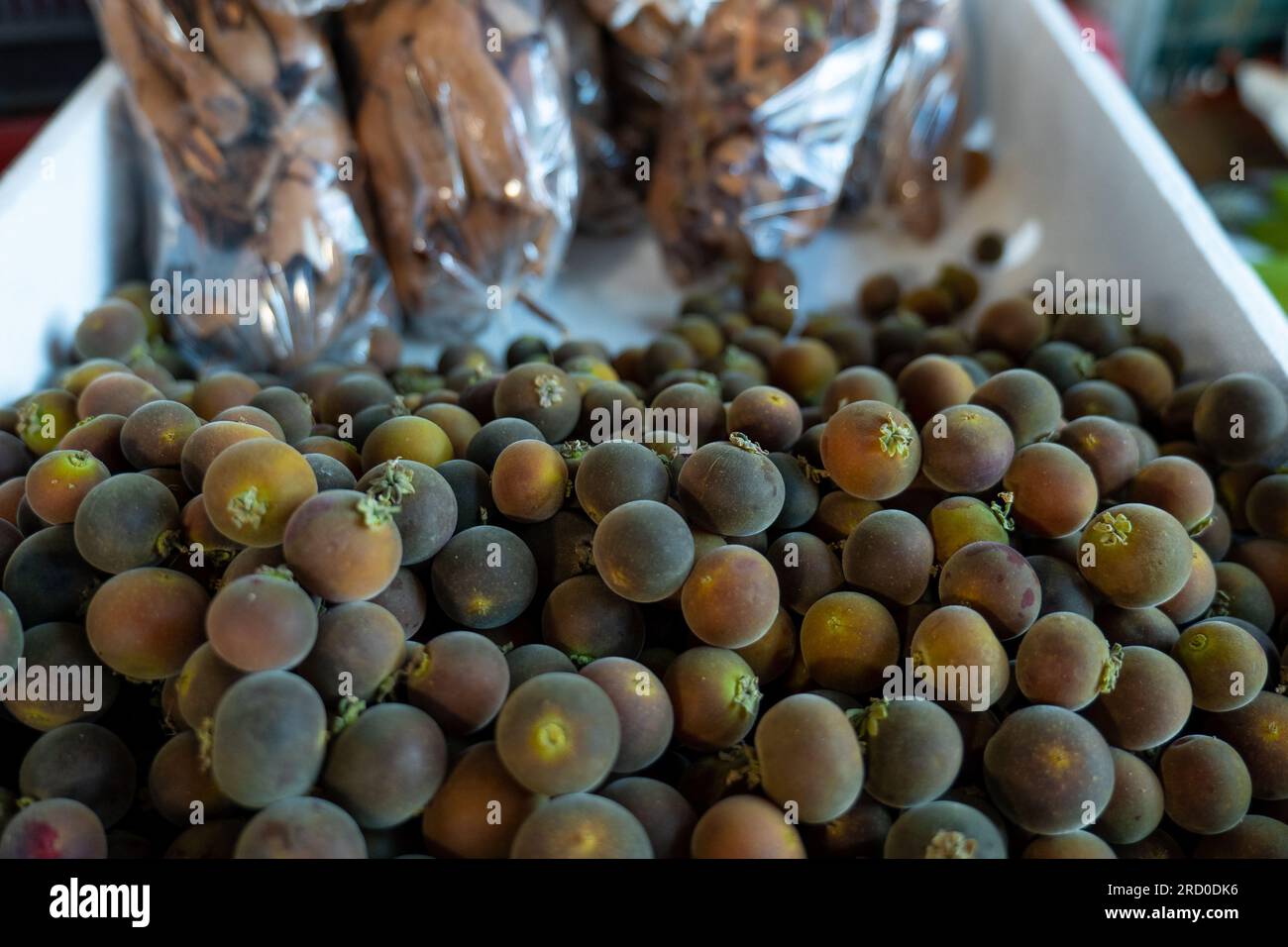 Close Up of a Bunch of Ripe Ketembilla (Dovyalis hebecarpa) Sour Purple Fruit Also Called Ceylon Gooseberry Native to Sri Lanka and India on a Stall i Stock Photo