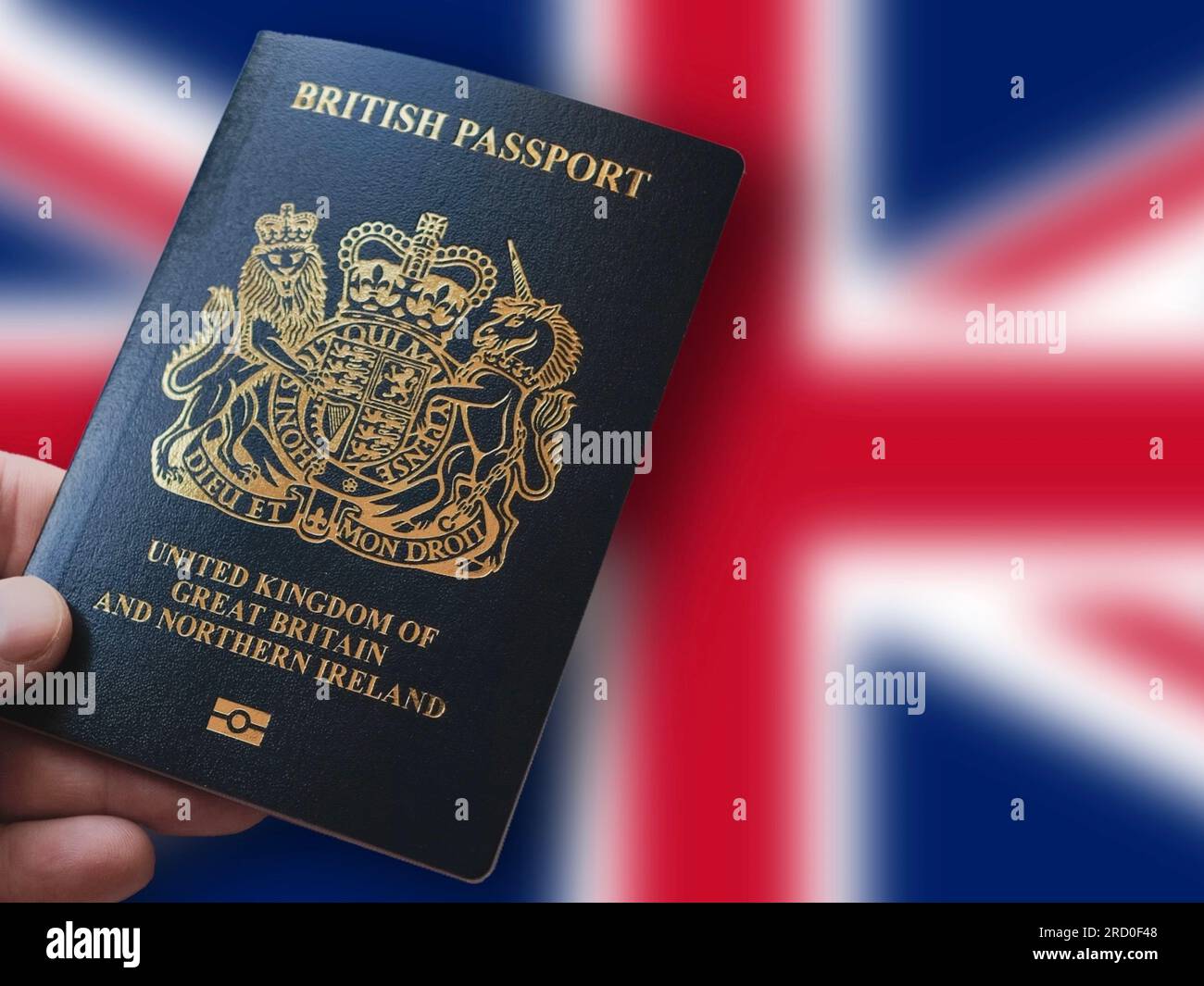 Hand holding a British Passport in front of the Union Jack. Travel