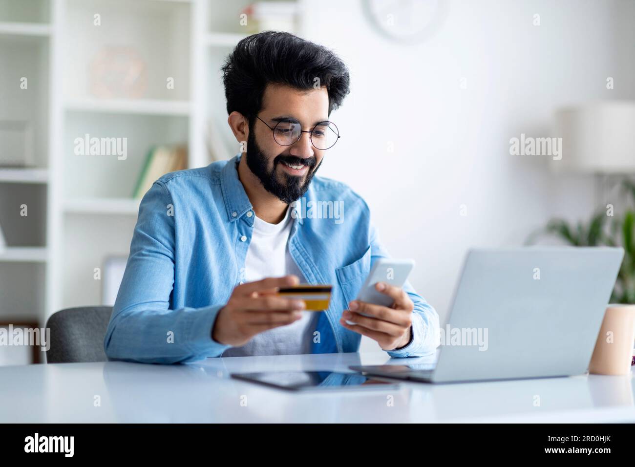 E-Commerce Concept. Smiling Indian Man Holding Credit Card And Using ...