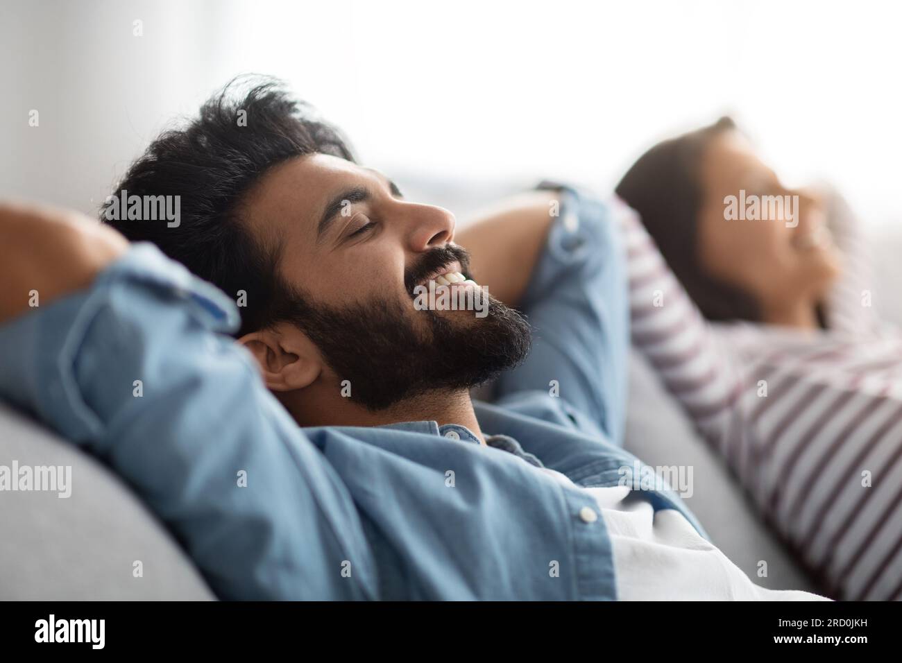 Satisfied eastern young spouses resting at home Stock Photo