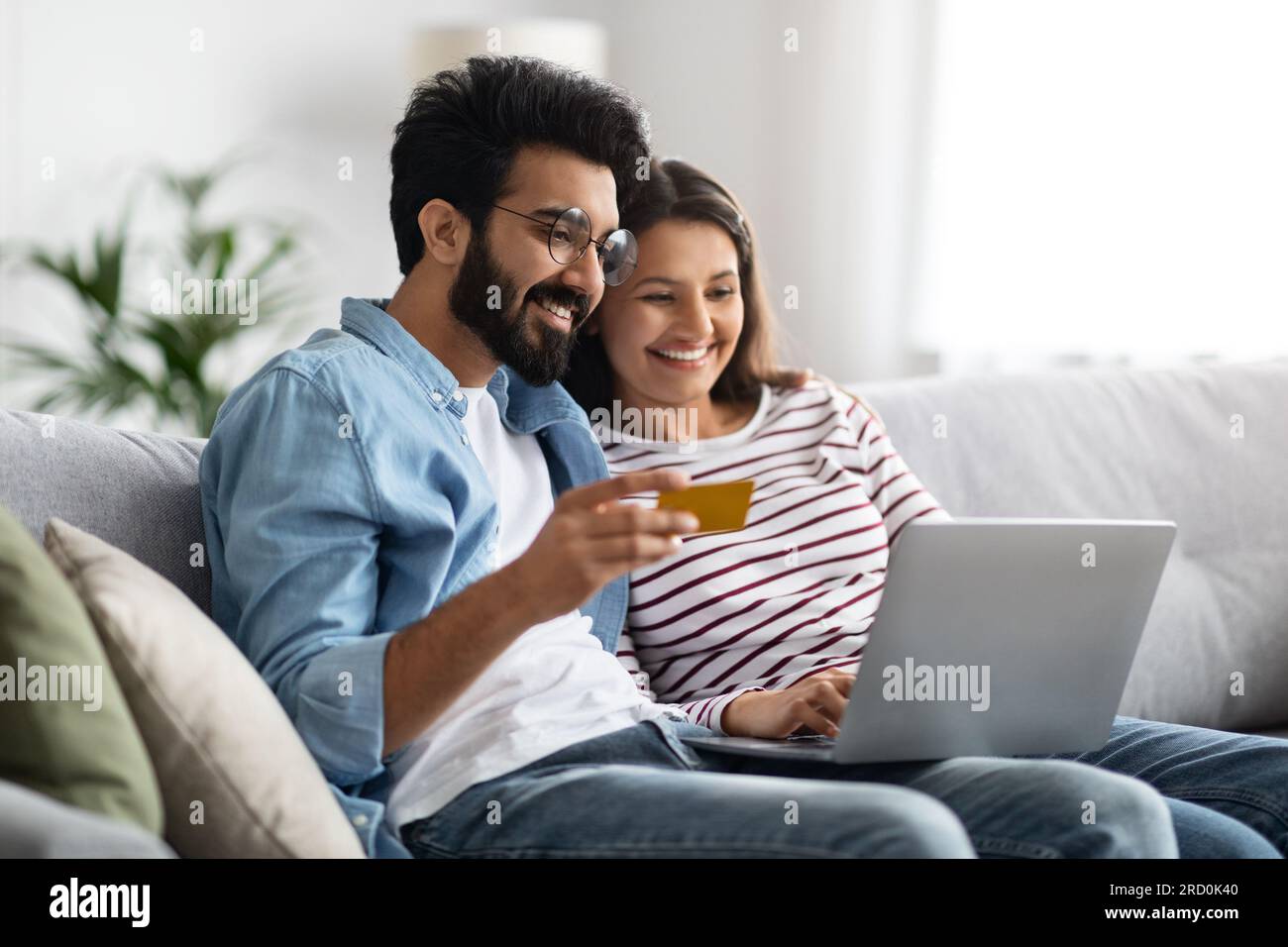 Happy indian couple with bank card and laptop at home Stock Photo - Alamy