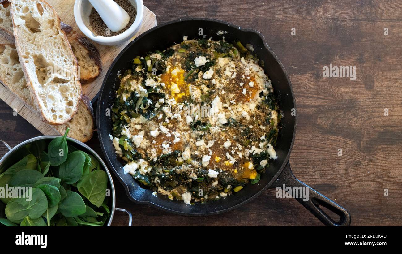 Eggs and Spinach omelet set with bread and spinach leaves Stock Photo