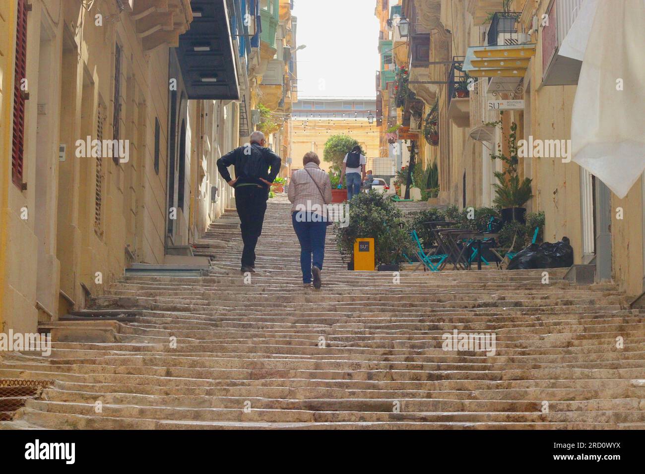 Tourists wearily climb up the long series of steps at St Ursula Street, Valletta, Malta, April 2023. Stock Photo