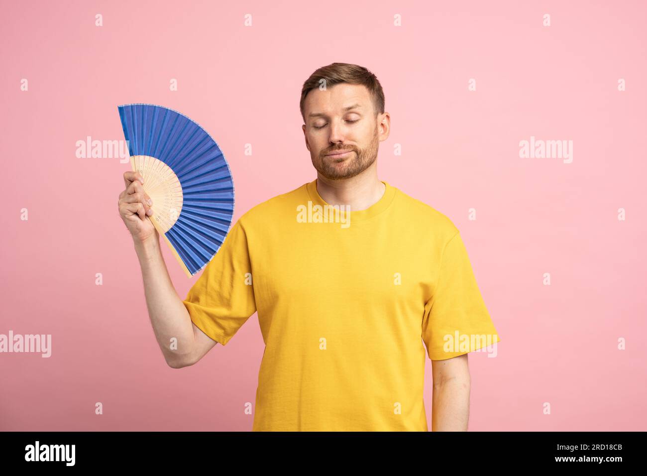 Exhausted man using paper fan suffer from heat. Overheating, stuffiness