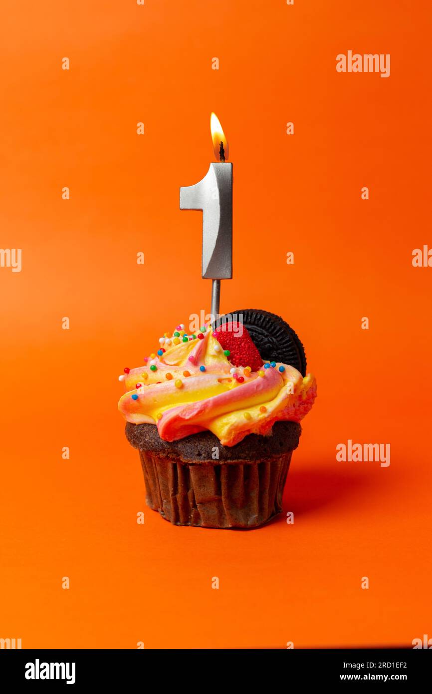 birthday cake with number 1 - cupcake on orange background with birthday candles Stock Photo